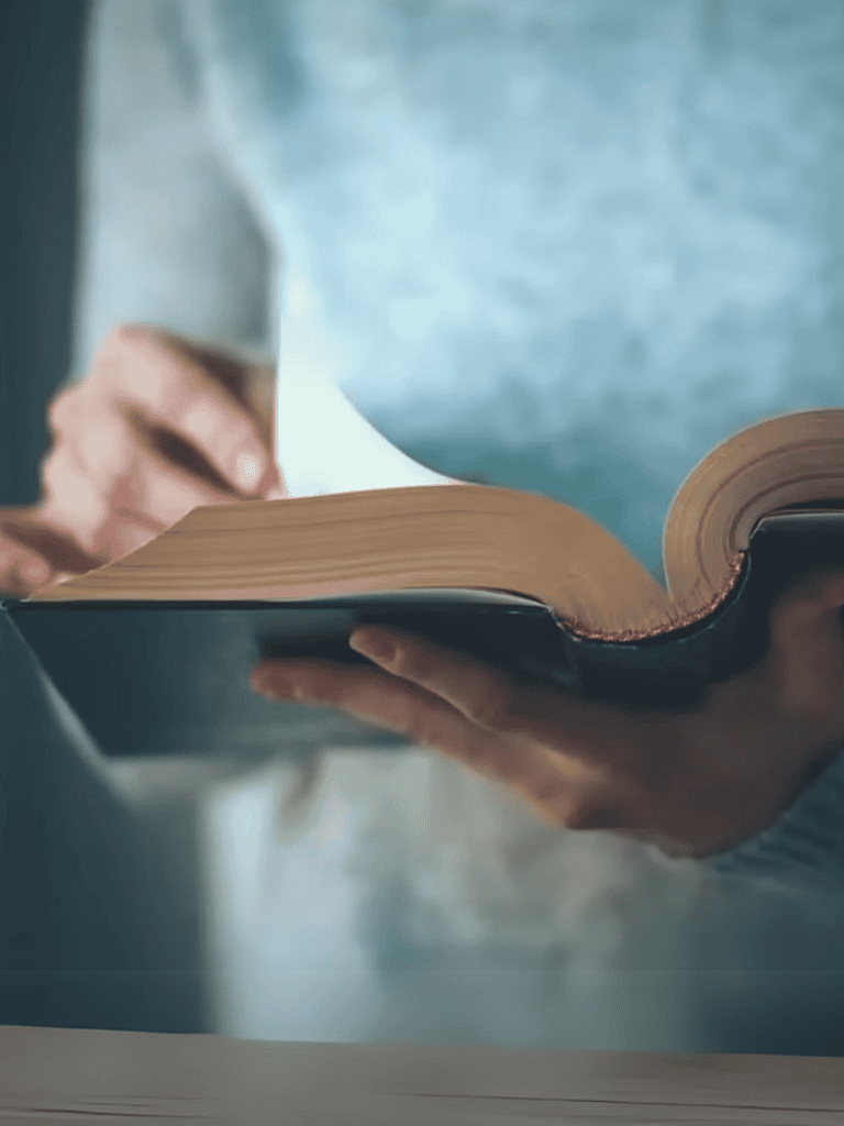 Close-up of someone holding an open book, emphasizing reading and literature.